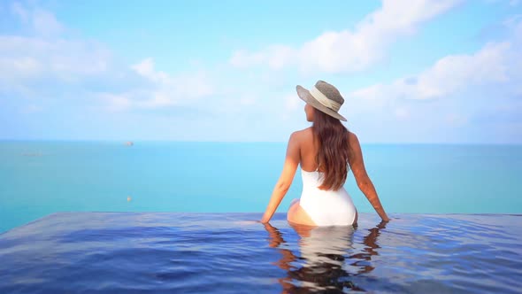 Young asian woman enjoy around outdoor swimming pool for leisure