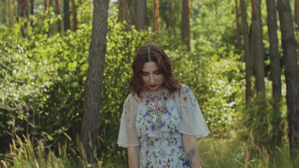 Attractive Woman with Red Lips Touches Her Curly Hair Walk in the Forest Slow Motion