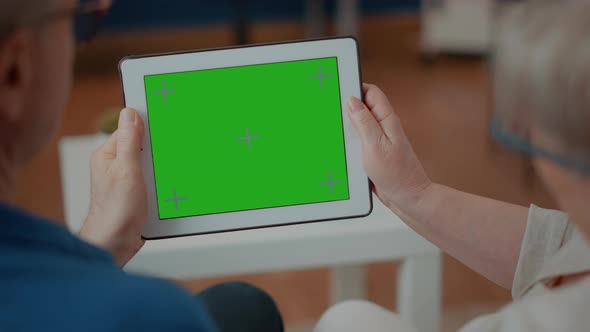 Senior Couple Holding Digital Device with Green Screen