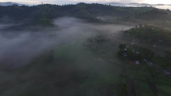 Aerial shot of villages covered by mist in Uganda 