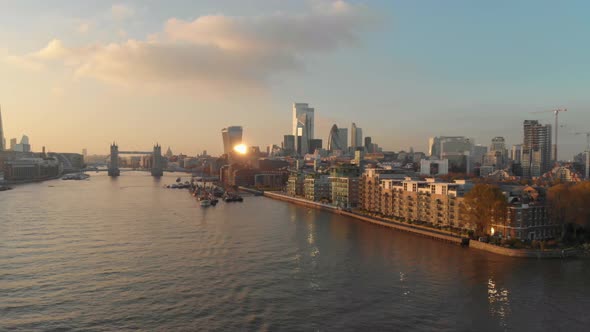 slider drone shot over London Thames river towards city centre over residential building sunset