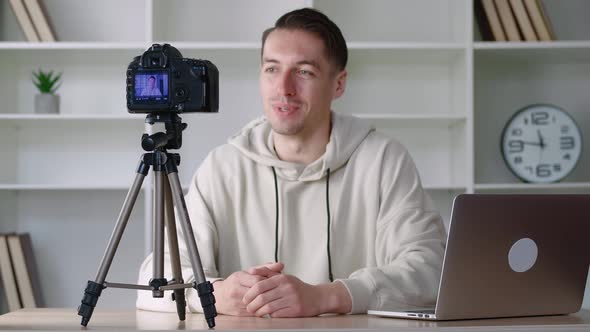 Young Blogger Man Filming New Vlog Video with Professional Camera at Workplace at Office