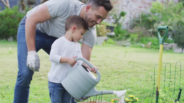 Happy caucasian father and son gardening and watering plants together