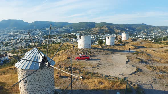 Old Windmills in Bodrum. Group of Friends Taking Photos on the Background. Welcome To Turkey Concept