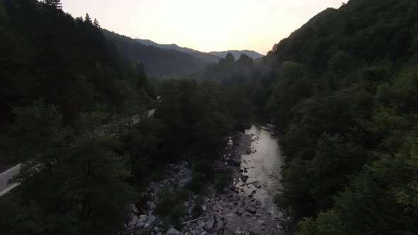 FPV Aerial Shot Dynamic Flying at Natural Landscape River Canyon in the Dense Green Forest and Rapid