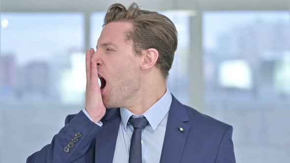 Portrait of Sleepy Young Businessman Yawning in Office 