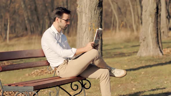 Businessman Relaxing And Reading Fresh Newspaper.Man Rest Sitting On Bench And Reading Newspaper