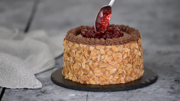 Decorating the Chocolate Layer Cake with Cherries. Pastry Chef Is Cooking Homemade Cake.