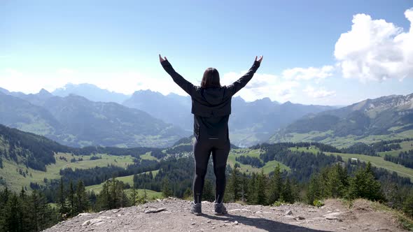 Accomplishment - Female Hiker at Scenic Overlook Mountaintop Peak in Switzerland, Static Tripod View