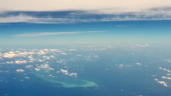 Amazing aerial view of atoll of turquoise Maldives archipelago and clouds