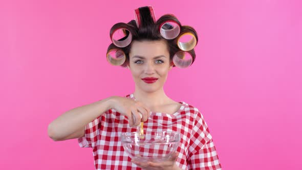 Woman in Hair Rollers Cracking Egg