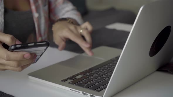 Beautiful Female Hands Using Laptop and Smartphone.