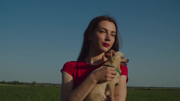 Relaxed Pretty Woman Holding Chihuahua Dog Outdoors