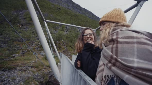 Women walking on bridge above canyon