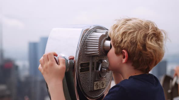 Boy Looking Through Telescope To View New York Skyscrapers