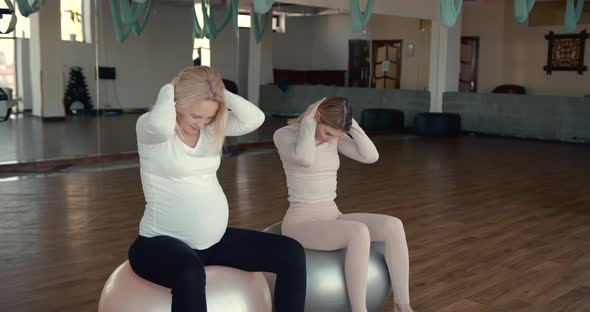 Pregnant Woman and Her Personal Trainer Doing Stretching Exercises