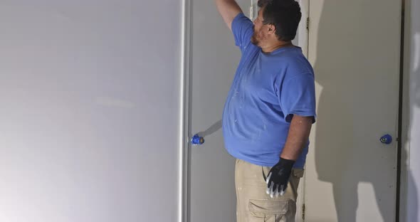 Contractor Painting a Wooden Door Using Paintbrush alt