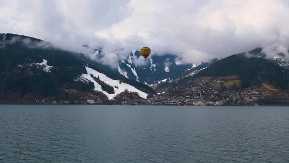hot air ballon aerostat flying over mountain lake