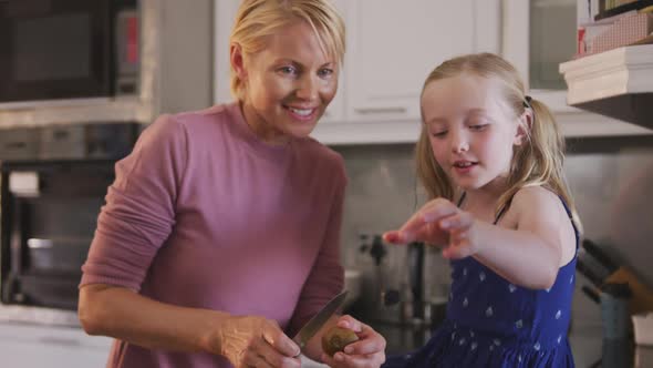 Front view of Caucasian woman with her daughter in the kitchen