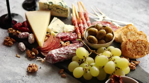 Cold Snacks Board with Meats, Grapes, Wine, Various Kinds of Cheese