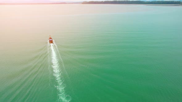 An aerial view of a boat cruising forward into the estuary