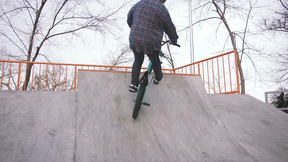 BMX Rider Doing Tricks in Street Plaza Bicycle Stunt Rider in Cocncrete Skatepark Super Slow Motion