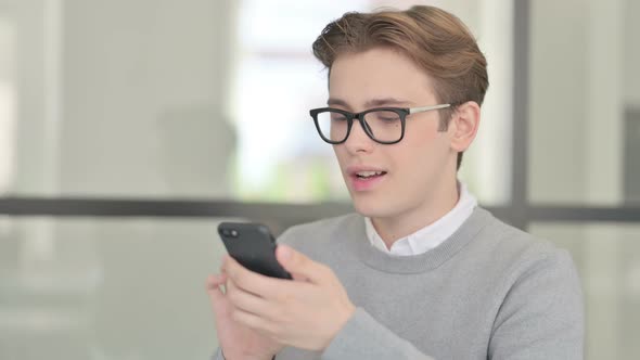 Young Man Celebrating on Smartphone