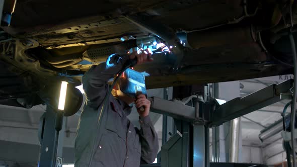 Closeup Welding Work on a Lifted Car