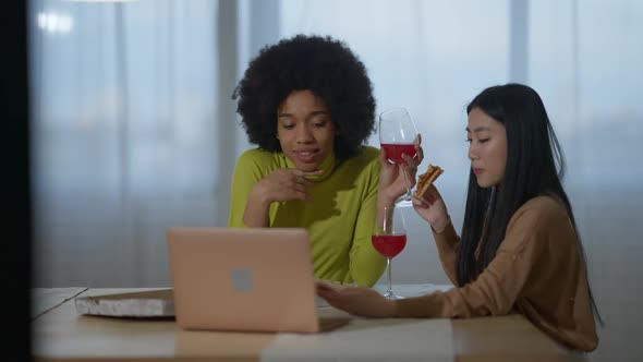 Beautiful African American and Asian Women Surfing Social Media Talking and Smiling Drinking Red