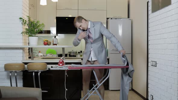 Handsome Businessman in Tie Ironing Pants at Home. Preparing for Meeting