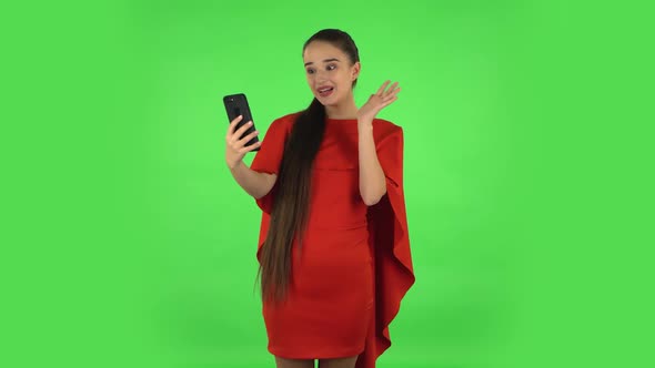 Pretty Young Woman Is Talking for Video Chat Using Mobile Phone and Rejoice. Green Screen