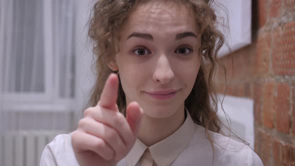 Serious Female Pointing at Camera with Finger