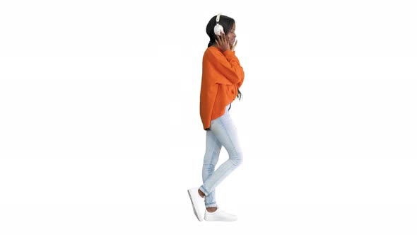 Young African American Woman with Headphones Listening and Grooving To Music on White Background