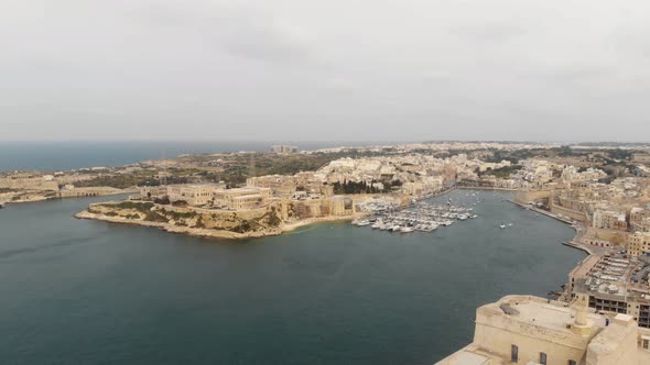 Wide panning 4k Drone footage of the 'Three Cities of Malta' along the Mediterranean coast
