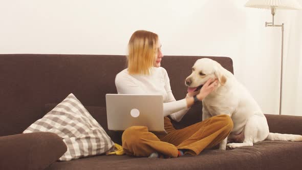 Happy Attractive Girl Hugs a Big White Dog.