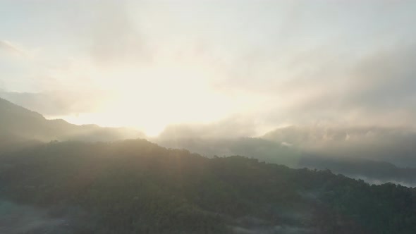 Drone Flight In Sunlit Sky Over Misty Landscape