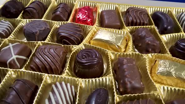 Box of chocolate bonbon rotating. Close up on mixed chocolates