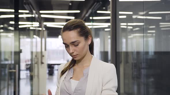 30-Aged Office Manager Looking at I-pad and Posing on Camera with Sincerely Smile