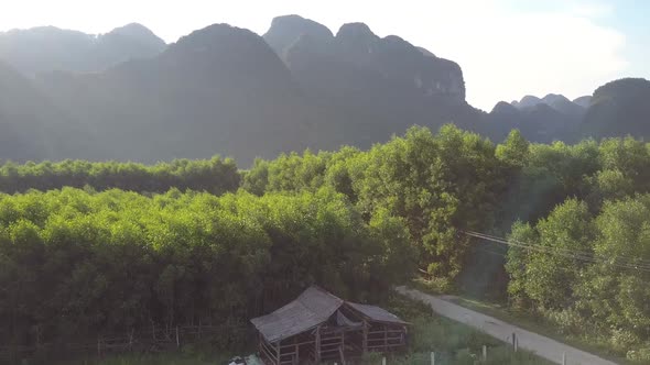 Shed at Grove and Small Town Against Mountains Upper View