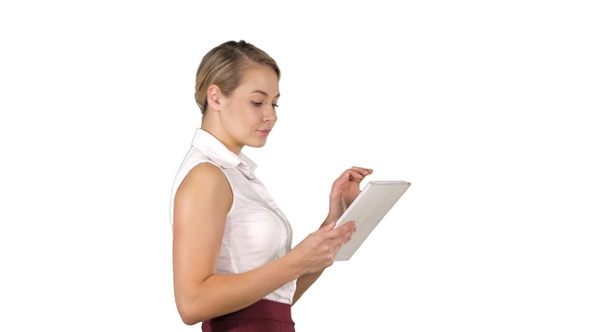 Modern businesswoman using tablet computer while walking