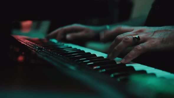 Musicians playing at a wedding. Man is playing synthesizer. Stage lights