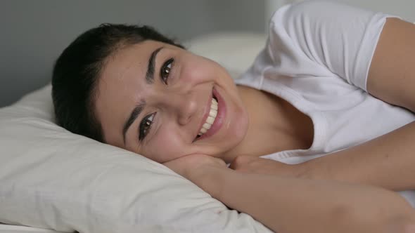 Indian Woman Laying in Bed Smiling at Camera 