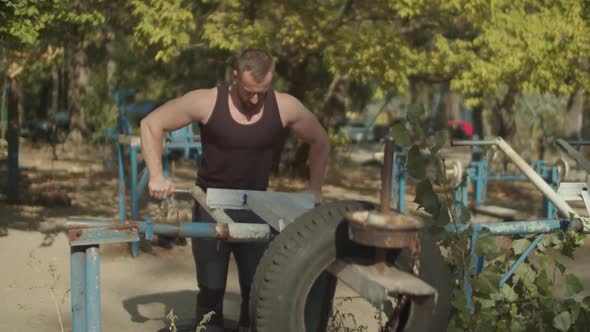 Muscular Man Doing Triceps Exercise at Outdoor Gym