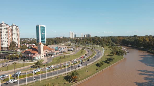 Aerial establishing shot of Tigre city coast walk with weekend traffic at the avenue