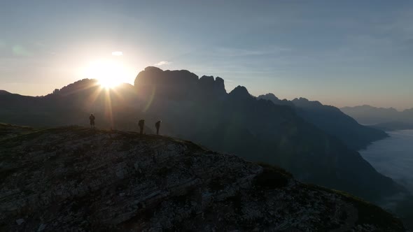 Female and male hikers at the top of the mountain at sunrise.