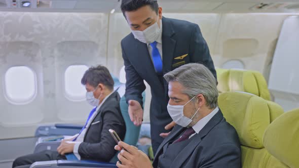 Group of business class passengers wearing mask sitting on airplane during the COVID-19 pandemic