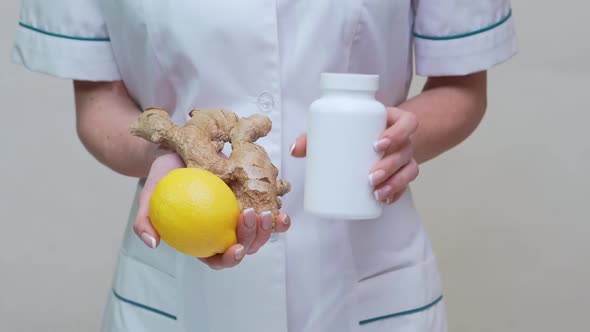 Nutritionist Doctor Healthy Lifestyle Concept - Holding Ginger Root, Lemon and Vitamin Pills