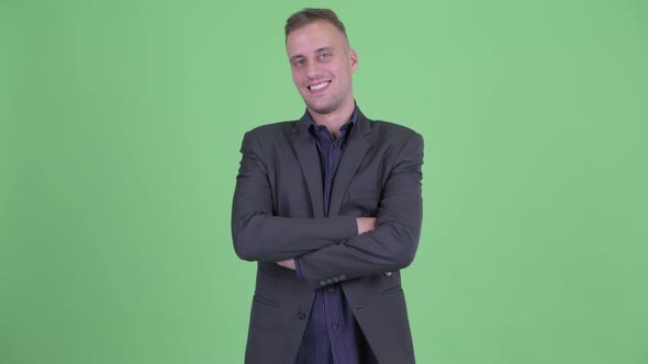 Happy Handsome Businessman in Suit Smiling with Arms Crossed