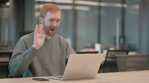 Young Man Talking on Video Call on Laptop in Office