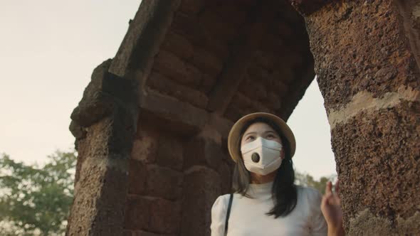 female woman wearing protective face mask walking and take photo with smartphone